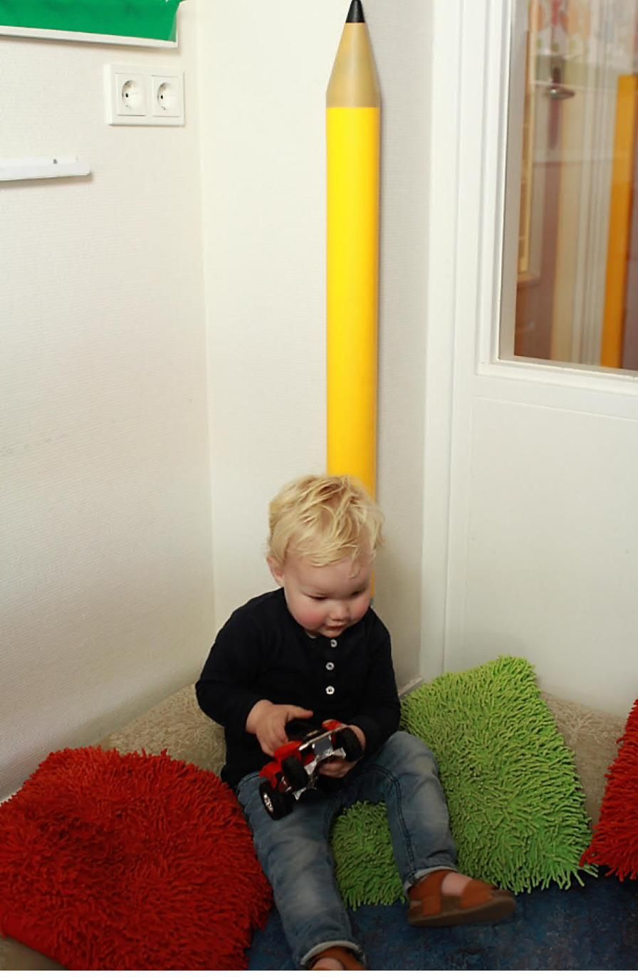 Enfant à côté d'une protection d'angle Corner Guard Deluxe rouge en forme de crayon